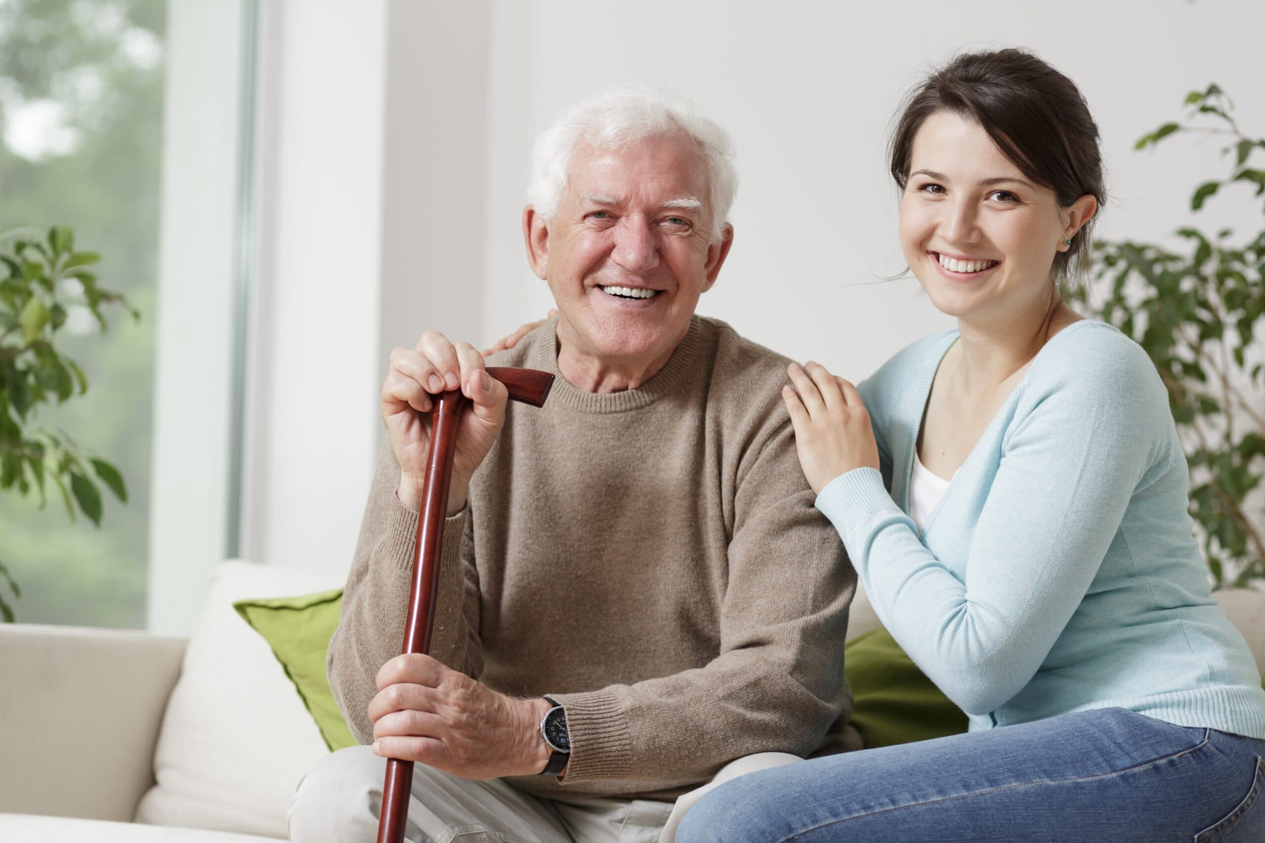 Smiling elderly man and caregiver spending time together at home